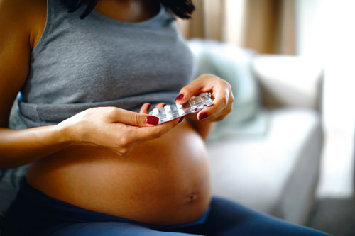 Femme enceinte tenant des médicaments